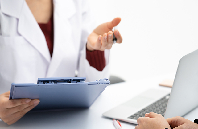 女性がバインダーを持って話している手元